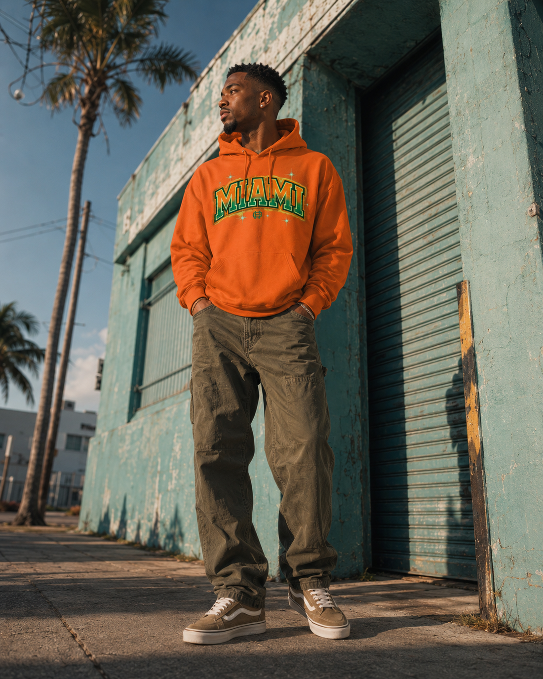 Model wearing the Miami Airbrush Fleece Hoodie in orange with orange and green Miami artwork, front lifestyle view