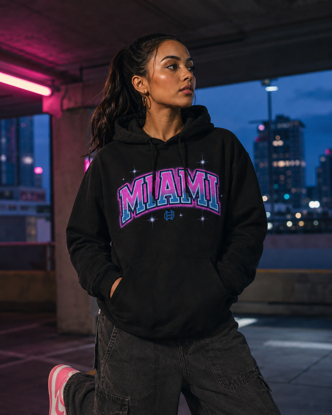 Model wearing the Miami Airbrush Fleece Hoodie in Vice black with pink and teal Miami artwork, front lifestyle view